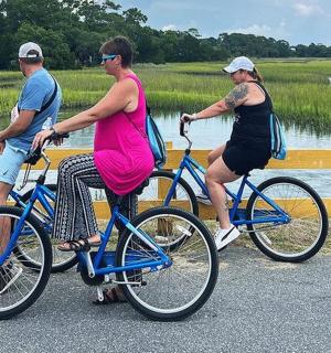 a group of people riding bikes next to a fence