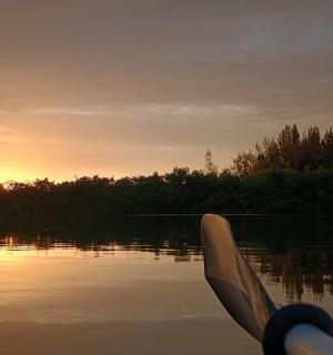 a person paddling a boat on a lake at sunset