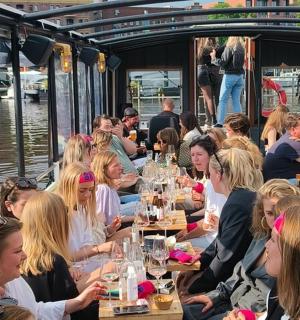 一群人坐在船上的桌子旁