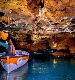 žena v lodi ve vodě v jeskyni
