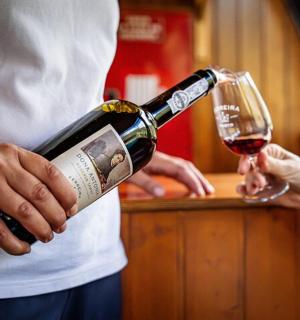 a person is pouring a glass of wine