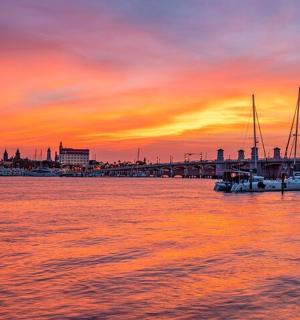 eine Gruppe von Booten im Wasser bei Sonnenuntergang