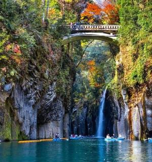 eine Brücke über ein Gewässer mit einem Wasserfall