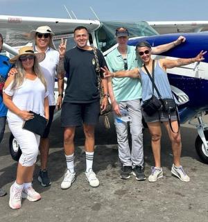 一群人站在一架小型飞机前