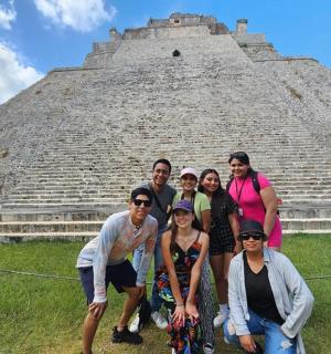 um grupo de pessoas posando em frente a uma pirâmide