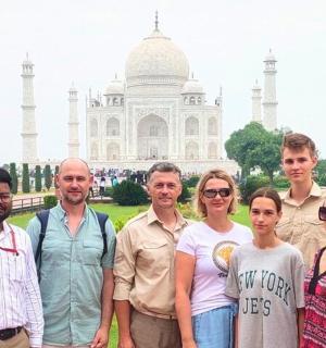 un gruppo di persone in piedi davanti al Taj Mahal