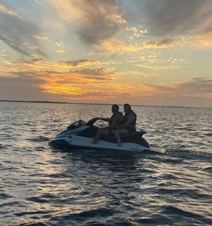 三个人坐在水上摩托艇上