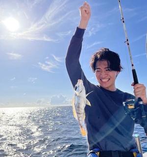 muž držící rybu v ruce na lodi