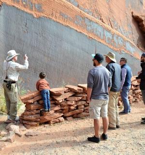 a group of people standing next to a wall