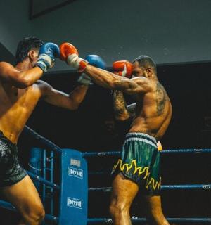 two men are fighting in a boxing match