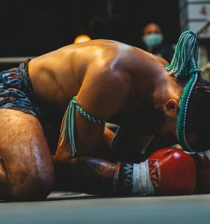 a man with a green rope on his head in a boxing ring
