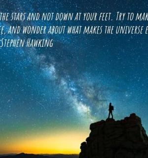 muž stojící na vrcholu hory pod noční oblohou