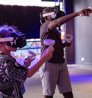 a woman standing next to a girl wearing virtual reality headsets