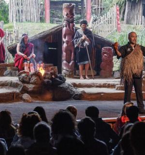 一名男子站在舞台上，面对着一群人