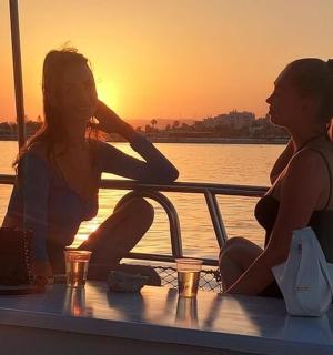 日落时分，两名女子坐在船上的桌子旁