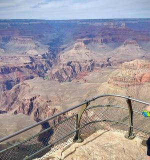 a woman is standing at the grand canyon