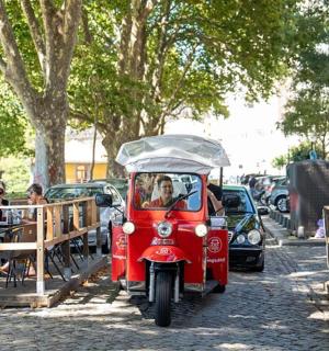 一辆带顶篷的红色摩托车在街上行驶