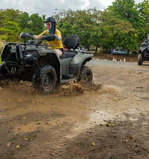 a man riding a four wheeler on a dirt road