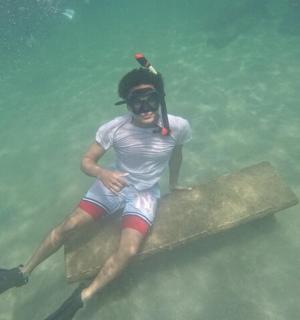 一名男子坐在水中的长椅上