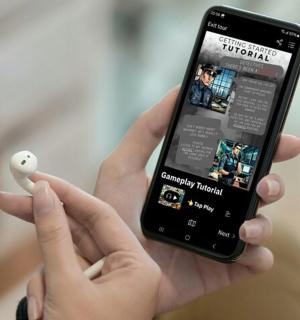 a person holding a smart phone with a video game