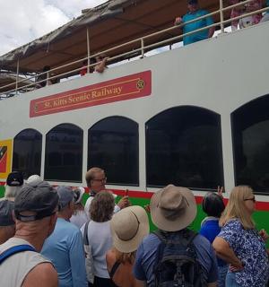 grupė žmonių, stovinčių priešais traukinį