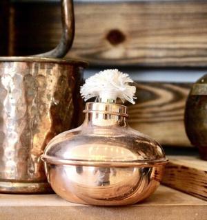 a glass jar with a flower in it sitting on a shelf