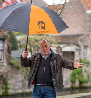 一位老人在雨中撑着伞