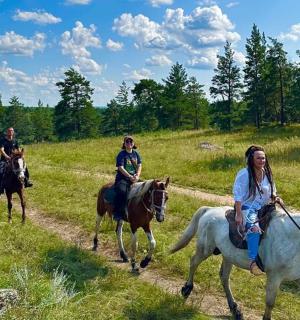 a group of people riding horses on a trail