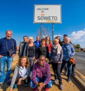 a group of people standing in front of a sign