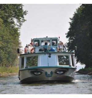 一艘沿着河流行驶的船,上面有一张脸