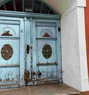 建筑物上有一扇蓝色的门和两扇窗户