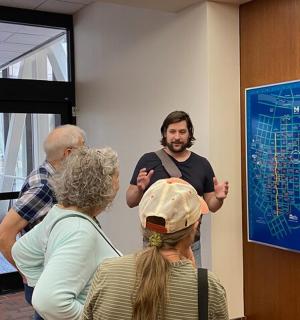 a group of people standing around a man in a room