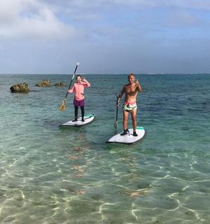 two women are standing on paddle boards in the ocean
