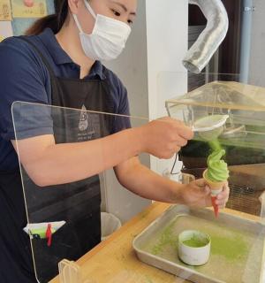 a woman in a face mask preparing food in a container