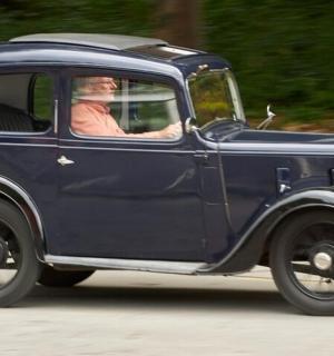 一名男子在路上驾驶一辆蓝色汽车