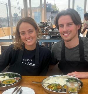 一男一女坐在桌边,吃着食物