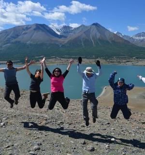 a group of people jumping in the air near a body of water