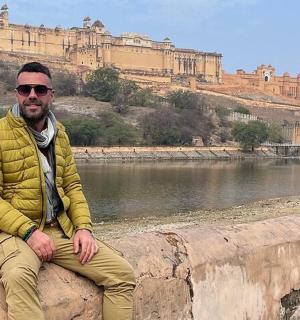 muž sedící na zdi vedle vodní plochy