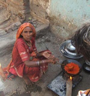 žena a dítě vařící jídlo na ohni
