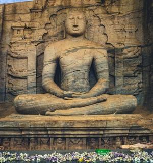 一名男子坐在岩壁上的雕像