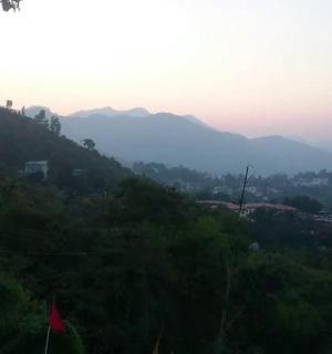 a view of a hill with mountains in the background