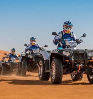 一群人在沙漠中骑着四轮摩托车