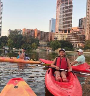 Skupina lidí jezdících na kajaku na řece ve městě