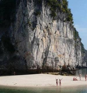 a group of people on a beach next to a mountain