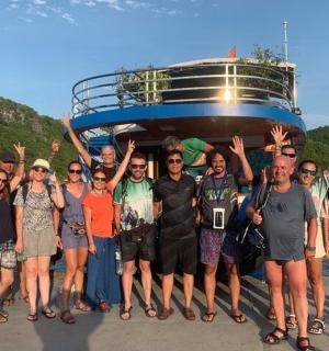 a group of people standing in front of a boat