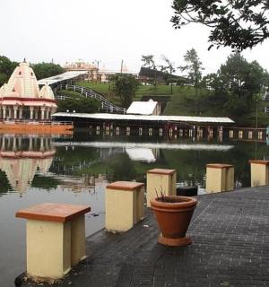 a pond with a gazebo and a building in the water