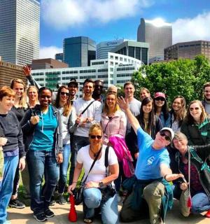 un grup de persones posant per a una foto davant d'una ciutat