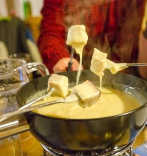 a person is stirring a bowl of food with spoons