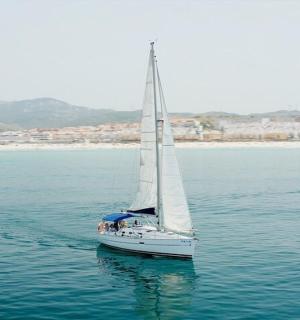 海滩附近水中的一艘白色帆船