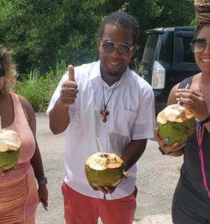 一名男子和两名女子拿着两个椰子